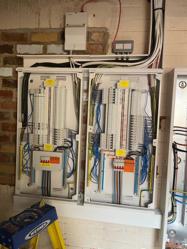Two electrical distribution boards with multiple neatly arranged cables.