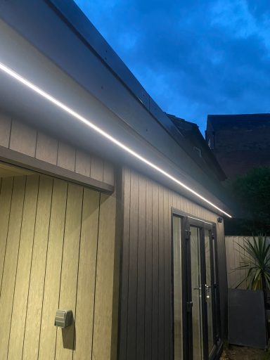 Exterior of a building at dusk, featuring LED strip lighting along the roofline.