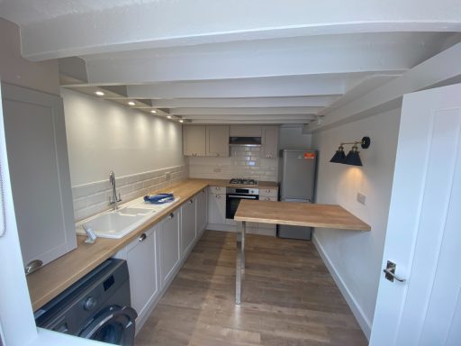 Modern kitchen with wooden countertops, sink, and appliances in a bright, spacious layout.